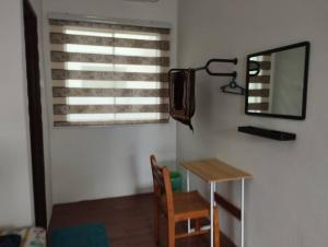 a room with a table and a mirror and a chair at D'Tanjung Roomstay, Pekan Pahang in Pekan