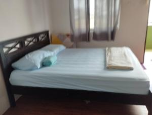 a bed with two pillows and a blanket on it at D'Tanjung Roomstay, Pekan Pahang in Pekan