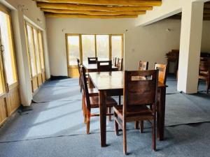 a dining room with a wooden table and chairs at Hunder Tamarix Resort in Hundar +15 photos