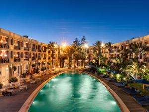 a swimming pool in the middle of a courtyard with buildings at Le Médina Essaouira Thalassa Sea & Spa - MGallery Collection in Essaouira