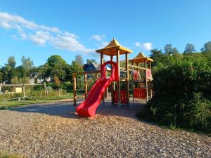 a playground with a red slide in a park at Ferienhaus Birkelbach in Erndtebrück