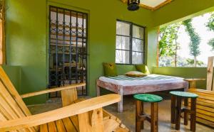 a green room with a table and two stools at Kitanda Msituni in Meru