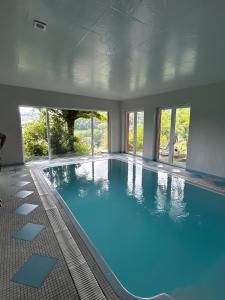 a large indoor swimming pool with blue water at Mediterranes Gelbes Haus Pool Sauna in Königheim