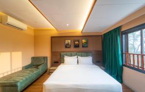 a bedroom with a large bed and a couch at Orient Beacon Resort, Panchgani in Mahabaleshwar