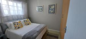 a small bedroom with a bed and a window at Greydoor 2 in Gqeberha