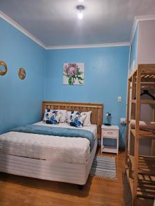 a bedroom with a large bed with blue walls at Zufike Self Catering in Port Elizabeth +101 photos