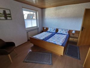 ein kleines Schlafzimmer mit einem Bett und einem Fenster in der Unterkunft Ferienwohnungen 'Blick Zur Madonna' in Fischbach