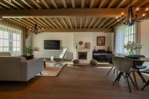 a living room with a table and a fireplace at Welcome in - Vakantiehuis Boerderij Molenhof met een riante tuin en rustig gelegen in Heinkensand