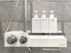 a white washing machine with four bottles on it at House of Hyuni in Busan +37 photos