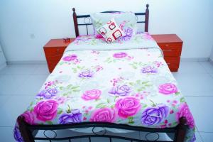 卡卢特勒DRS Luxury Holiday Home的一张带粉红色和白色床单及玫瑰的床