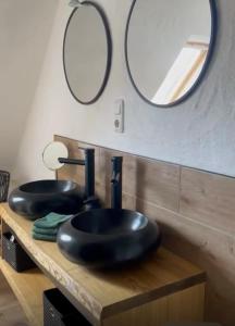 a bathroom with two black sinks and two mirrors at Landhaus "Marcomagus" in Kall +33 photos