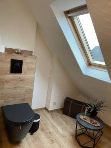 a attic room with a toilet and a table at Landhaus "Marcomagus" in Kall