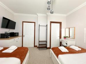 伦敦Fulham Rooms的一间卧室配有两张床和一张带镜子的书桌