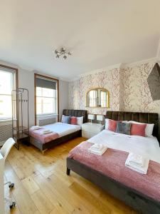 伦敦Fulham Rooms的带两张床和一张沙发的卧室