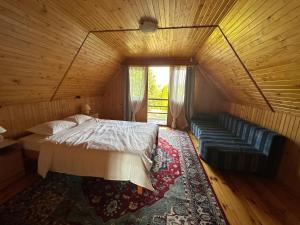 a bedroom with a bed and a couch in a room at Maison Xu - Le Chalet - Fireplace - River Beaches - Parking Garden Terrace in Nowa Wieś
