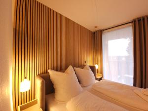 a bedroom with a bed with white pillows and a window at Alpenflair Apartment Winterberg in Winterberg