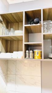 a kitchen with wooden cabinets with pots and pans at Lake View Muyenga Apartment in Kampala