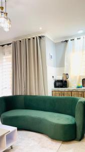 a green couch sitting in a living room at Lake View Muyenga Apartment in Kampala