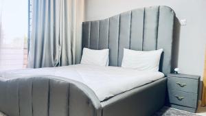 a bed with a large headboard in a bedroom at Lake View Muyenga Apartment in Kampala