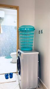 a washing machine with a blue basket on top of it at Lake View Muyenga Apartment in Kampala +19 photos