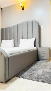 a bed with a gray headboard in a room at Lake View Muyenga Apartment in Kampala