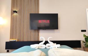 two white swans sitting on a bed in front of a tv at Le Cocon Studio in Brussels