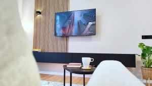a living room with a tv on a wall at Le Cocon Studio in Brussels
