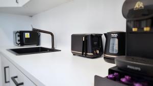 a white counter top with a coffee maker and a coffee appliance at Le Cocon Studio in Brussels