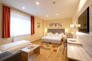 a hotel room with two beds and a couch at Hotel Schachenwald I Sauna I Aussenpool I Parkplatz in Premstätten +49 photos