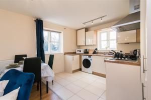 eine Küche und ein Esszimmer mit einem Tisch, einem Tisch und Stühlen in der Unterkunft Derby Dream 2 Bed Apartment - Close to City Center in Derby