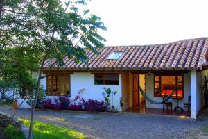 una pequeña casa blanca con techo rojo en Hostal Renacer en Villa de Leyva