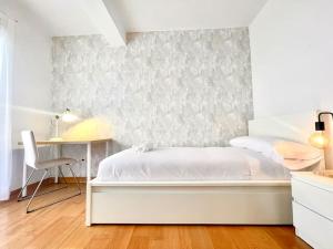 Un dormitorio blanco con una cama y un escritorio. en Ático Villa Isabella, en Granada