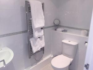 a white bathroom with a toilet and a sink at Gretenham B&B in Swanage +15 photos
