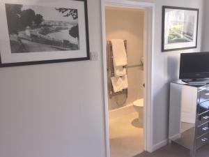 a bathroom with a toilet and a picture on the wall at Gretenham B&B in Swanage