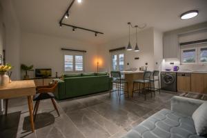 a living room and kitchen with a green couch at Anesis Apartment in Karditsa