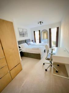 a bedroom with two beds and a desk in it at The Mirrored House in Kent