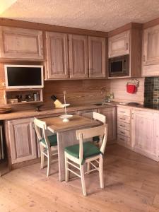 kuchnia z drewnianymi szafkami oraz drewnianym stołem i krzesłami w obiekcie Profumo di Legno a Cielo Alto La Coquille w mieście Breuil-Cervinia