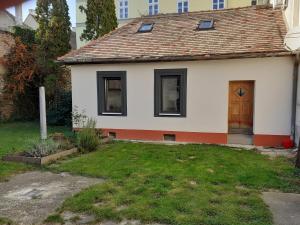 a small white house with a door and a yard at Varkor Villa at the castle in Kőszeg