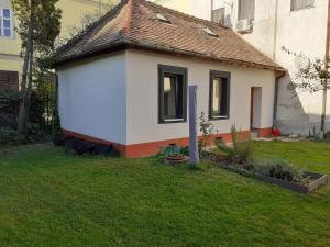 a small house with a roof on a yard at Varkor Villa at the castle in Kőszeg +3 photos