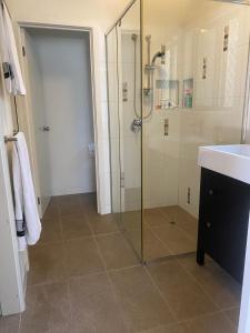 Un baño con ducha con puerta de cristal. en RYE RETREAT by the BEACH, en Rye
