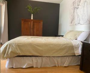 1 dormitorio con 1 cama grande y un jarrón en la pared en RYE RETREAT by the BEACH, en Rye