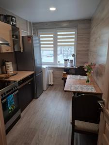 a small kitchen with a table and a counter top at Apartamentai Auris in Druskininkai