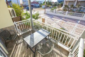 a patio with a table and chairs on a balcony at House Kohili in Nea Vrasna