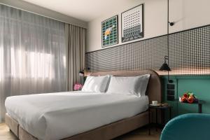 a bedroom with a large bed and a blue chair at Living Place Hotel in Villanova