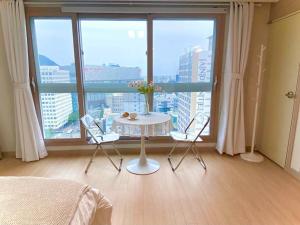 a room with a table and two chairs in front of a window at House of Hyuni in Busan