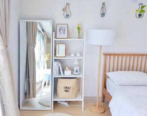 a bedroom with a mirror next to a bed at House of Hyuni in Busan
