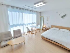 a bedroom with a bed and a table and chairs at House of Hyuni in Busan