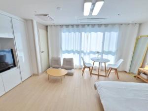 a living room with a table and chairs and a tv at House of Hyuni in Busan