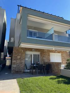 una casa con un tavolo e sedie di fronte di Luxury Villa Irinis a Nikiti