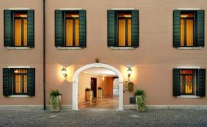 a pink building with an arch and windows at Residence La Fenice in Padova